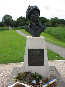 Buste af Major John Howard - stenen i baggrunden markerer stedet, hvor Glider nr. 1 landede